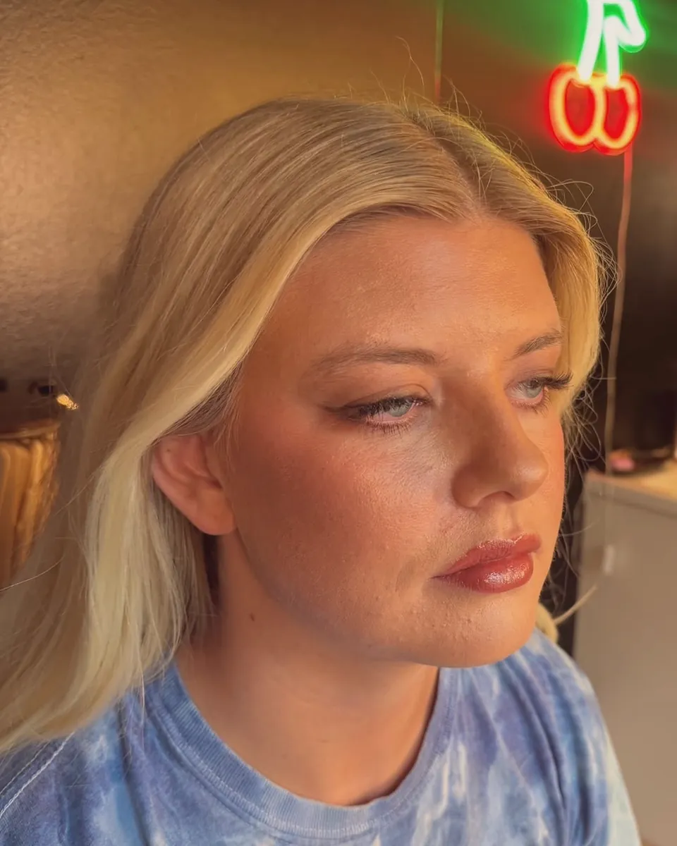 Glam on a client in the suite, the cherry neon glowing behind her.