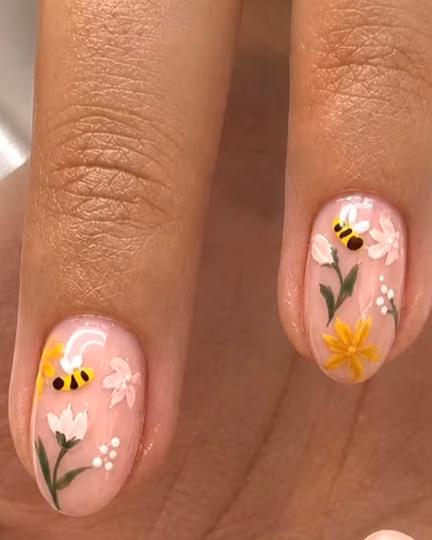 Soft pink nails with hand-painted flowers and little bees