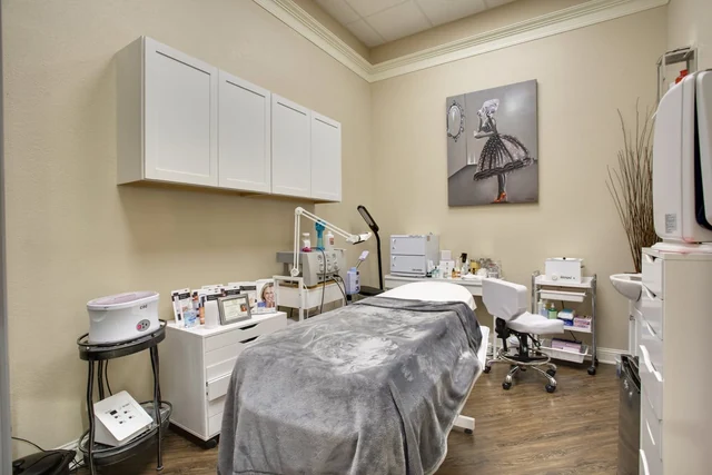A treatment room with cabinetry and a covered treatment bed.