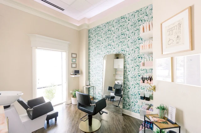 A furnished single-chair suite with a patterned feature wall.