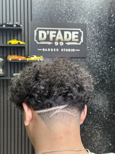 Curly haircut with a shaved line at the back, from D’Fade 99’s portfolio