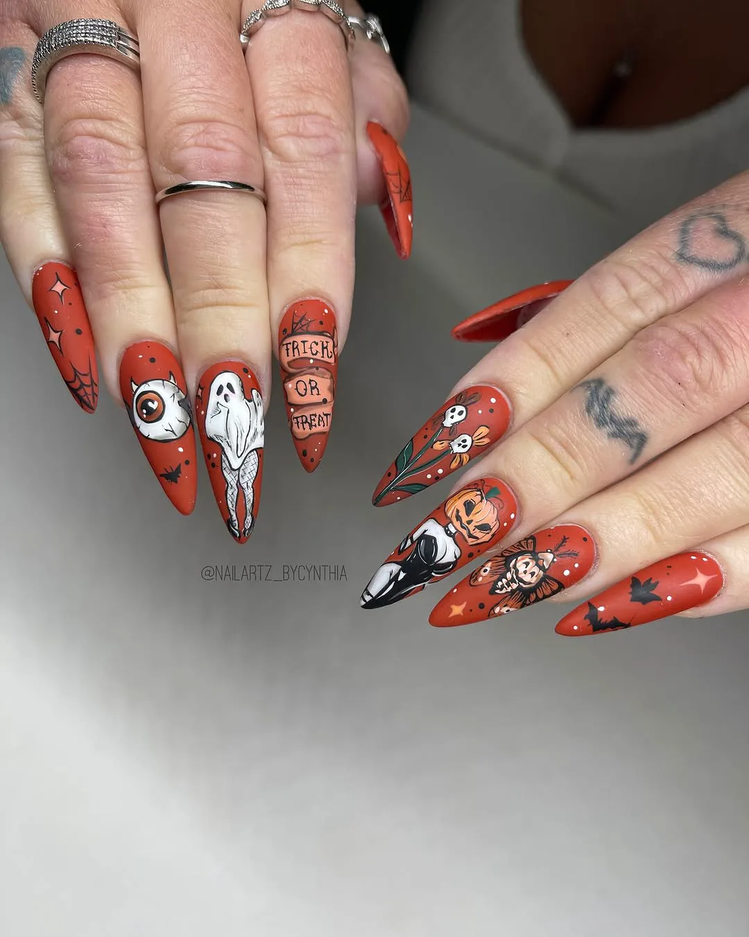 Long almond nails hand-painted with red and black illustrations, from Nail Artz by Cynthia’s Instagram