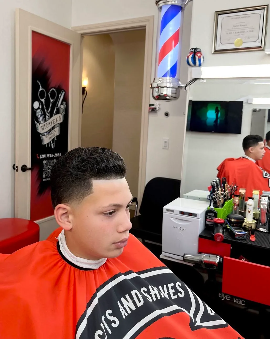 A client with a fresh fade in the barber chair, from Michel Barber Shop’s Instagram